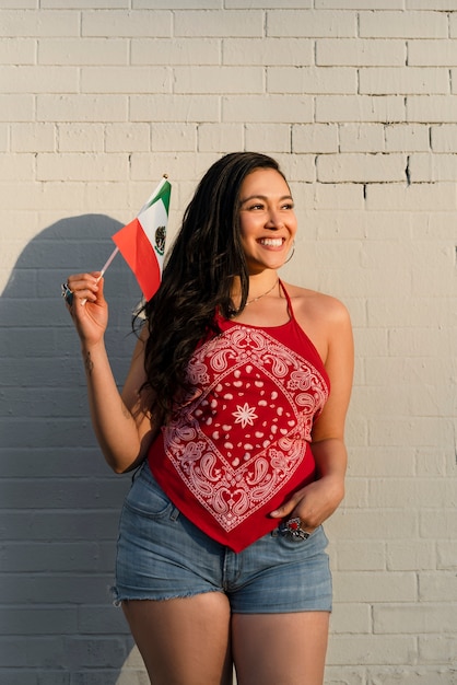 Foto gratuita mujer que sostiene la bandera mexicana en la calle