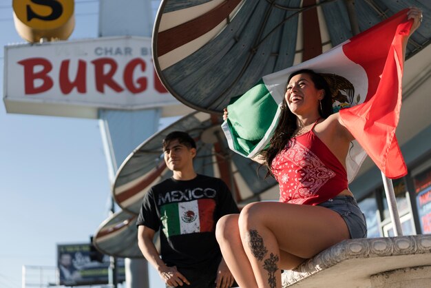 Mujer que sostiene la bandera mexicana en la calle