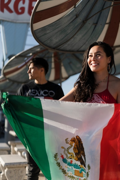 Mujer que sostiene la bandera mexicana en la calle