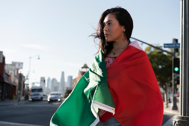 Foto gratuita mujer que sostiene la bandera mexicana en la calle