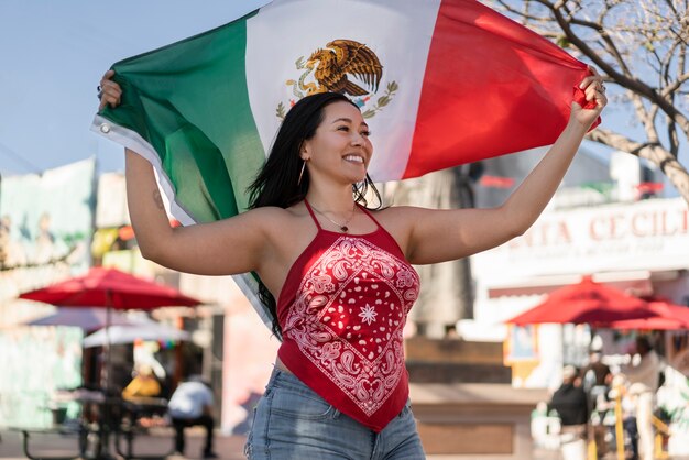 Mujer que sostiene la bandera mexicana en la calle