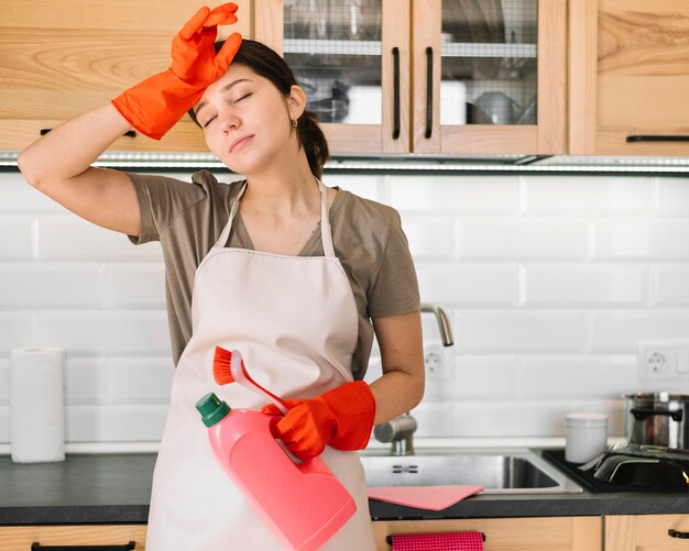 Mujer que sostiene la botella de detergente