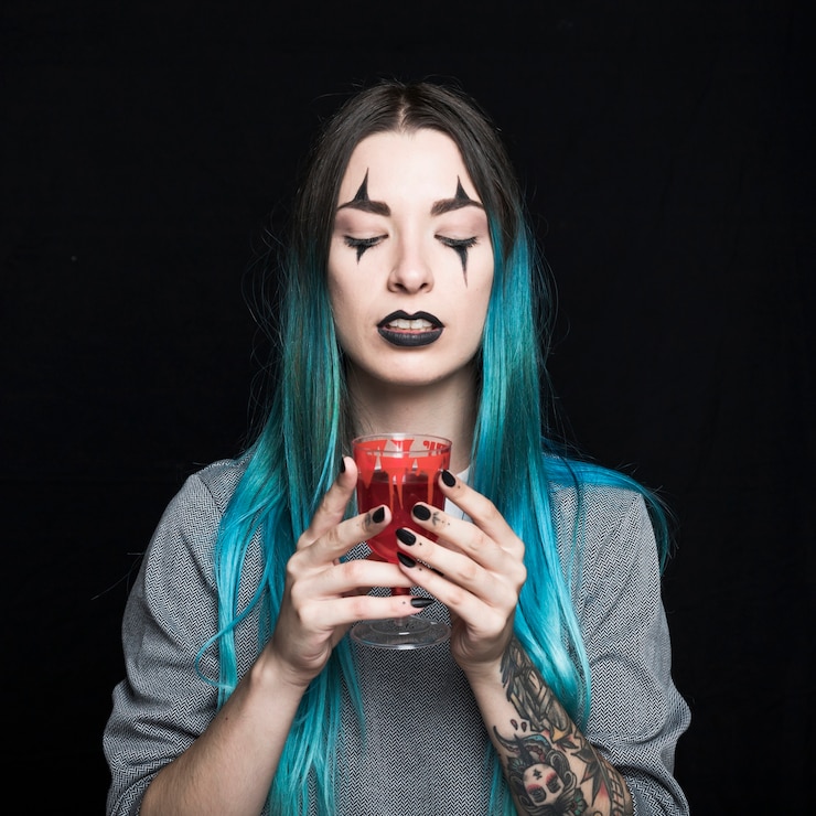 Foto gratuito mujer que sostiene el cáliz con bebida roja