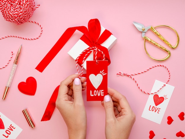 Foto gratuita mujer que sostiene la etiqueta del amor con los regalos