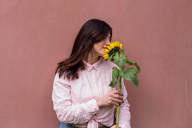 Mujer que sostiene la flor amarilla fresca