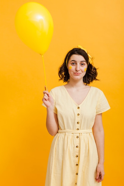 Foto gratuita mujer que sostiene el globo amarillo