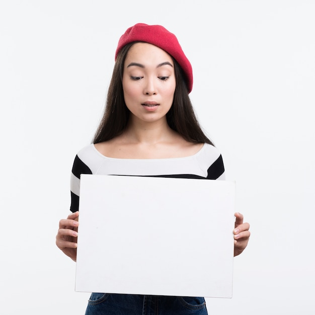 Mujer que sostiene la hoja de papel en blanco