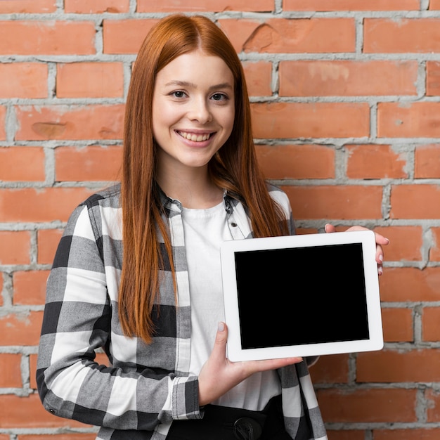 Mujer que sostiene el ipad en blanco