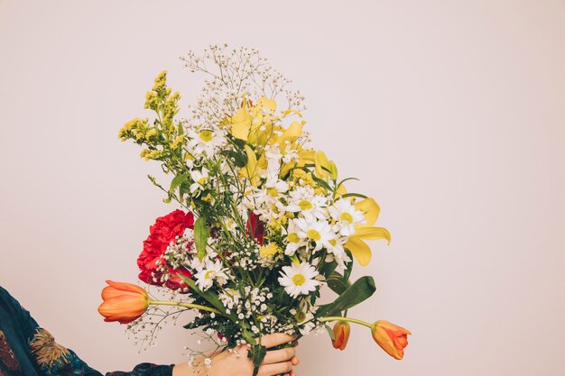 Mujer que sostiene el manojo de flores aromáticas frescas