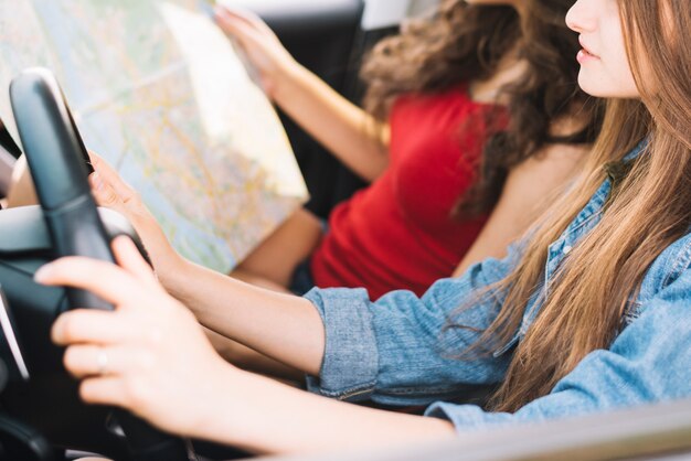 Mujer que sostiene el mapa en el coche