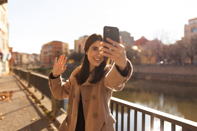 Mujer que sostiene el plano medio del teléfono inteligente