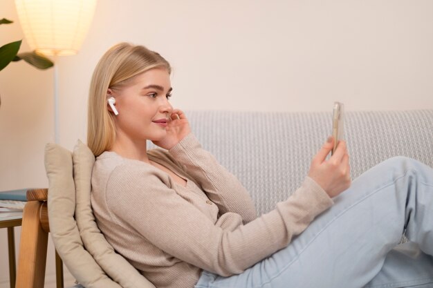 Mujer que sostiene el plano medio del teléfono inteligente