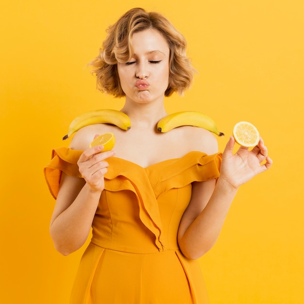 Mujer que sostiene plátanos y limón