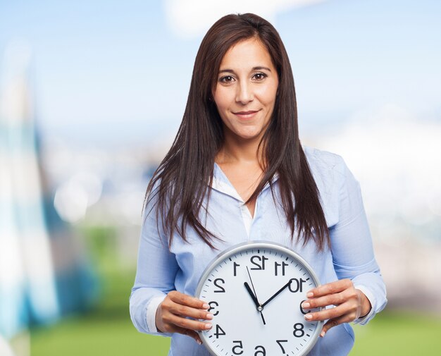 Mujer que sostiene un reloj