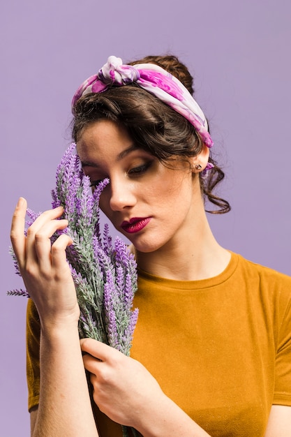 Foto gratuita mujer que sostiene el retrato de las flores de lavanda