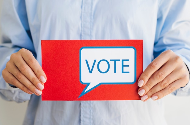 Mujer que sostiene la tarjeta roja con bocadillo de votación