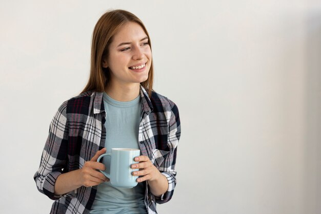 Mujer que sostiene una taza de café azul