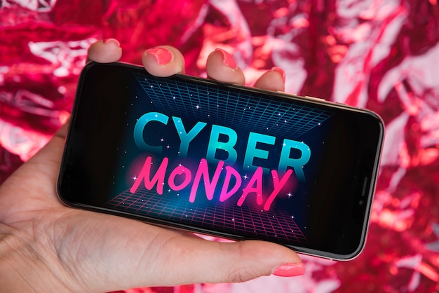 Foto gratuita mujer que sostiene el teléfono inteligente con la inscripción de cyber ​​monday