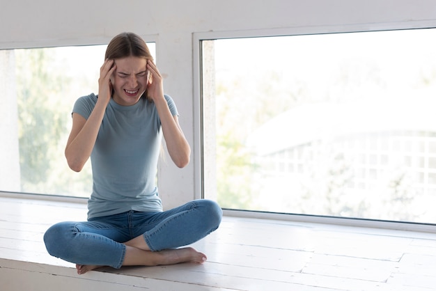 Foto gratuita mujer que tiene un dolor de cabeza con espacio de copia