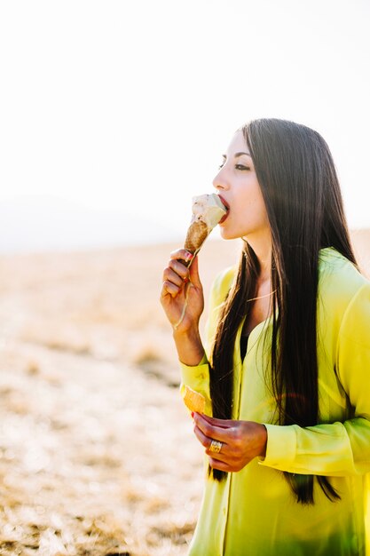 Mujer que tiene helado en un día soleado