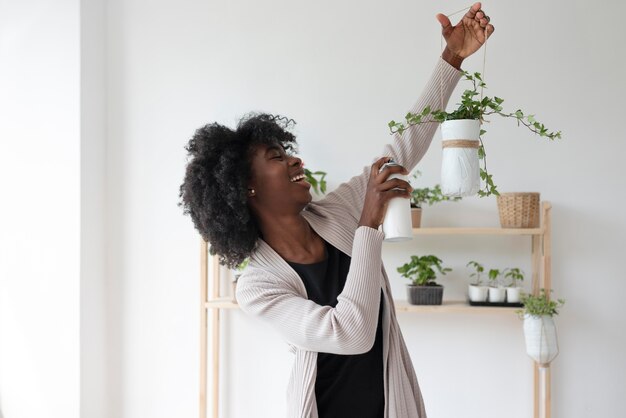 Mujer que tiene un jardín sostenible en el interior