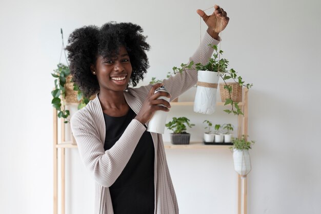 Mujer que tiene un jardín sostenible en el interior