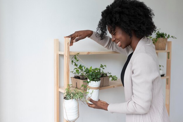 Mujer que tiene un jardín sostenible en el interior