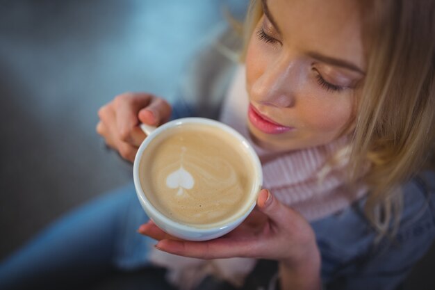 Mujer que tiene una taza de café en la cafetería ©