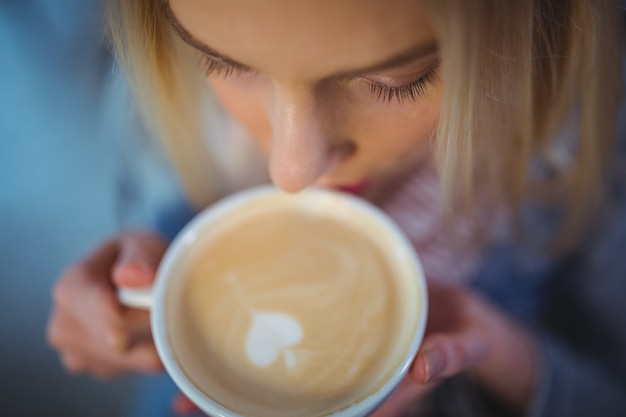 Mujer que tiene una taza de café en la cafetería ©