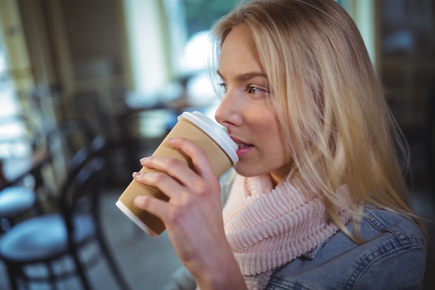 Mujer que tiene una taza de café en la cafetería ©