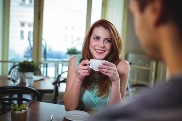 Mujer que tiene una taza de café en la cafetería ©