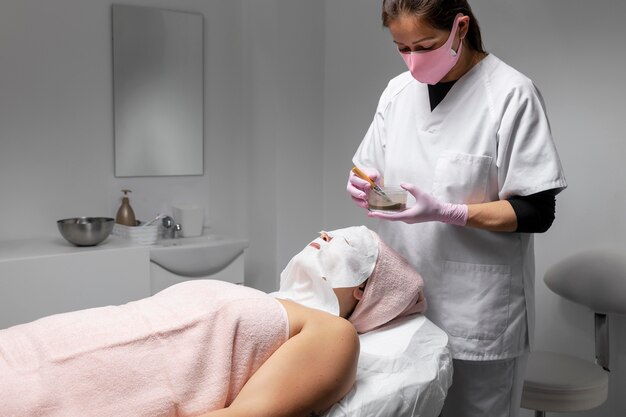 Mujer que tiene un tratamiento facial en el salón de belleza