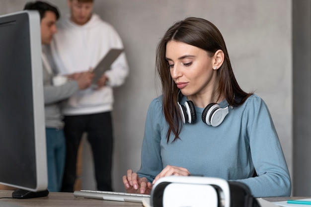 Mujer que trabaja en el campo de los medios de comunicación con colegas masculinos