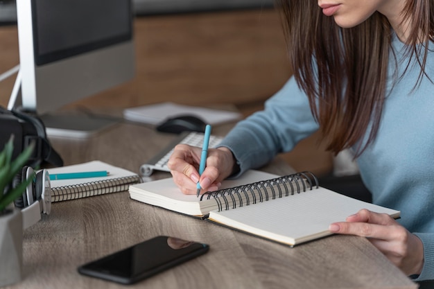 Mujer que trabaja en el campo de los medios de comunicación escribiendo cosas en el portátil