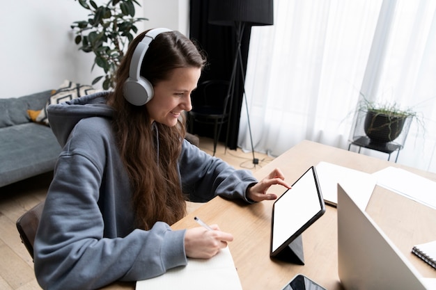 Foto gratuita mujer que trabaja desde casa en el escritorio con tableta