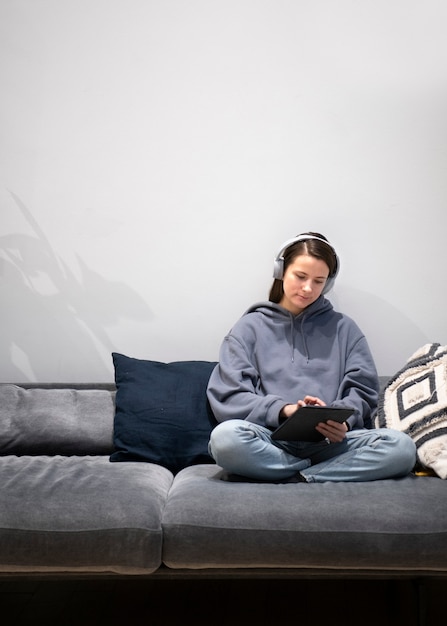 Mujer que trabaja desde casa en el sofá con tableta