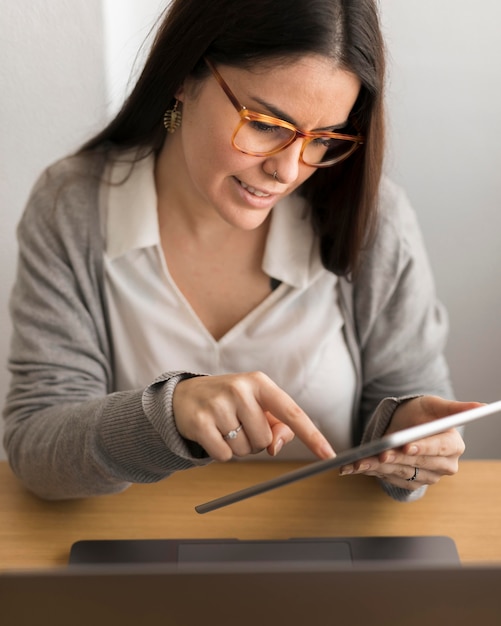 Mujer que trabaja en casa en tableta