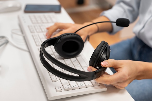 Mujer que trabaja en un centro de atención telefónica con un par de auriculares