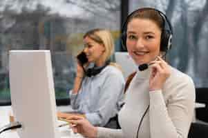 Foto gratuita mujer que trabaja en un centro de llamadas hablando con clientes usando auriculares y micrófono