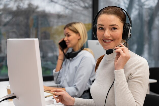Mujer que trabaja en un centro de llamadas hablando con clientes usando auriculares y micrófono