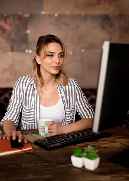 Mujer que trabaja en la computadora desde casa