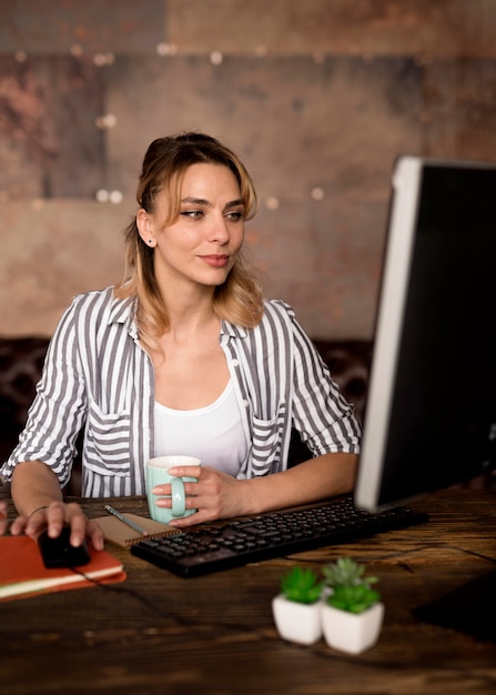 Mujer que trabaja en la computadora desde casa