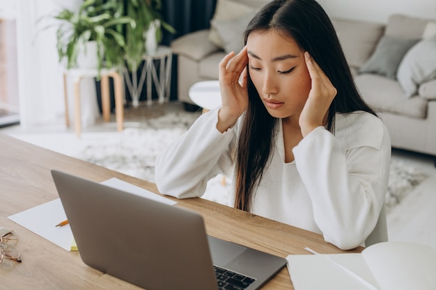 Mujer que trabaja en la computadora en el escritorio desde casa