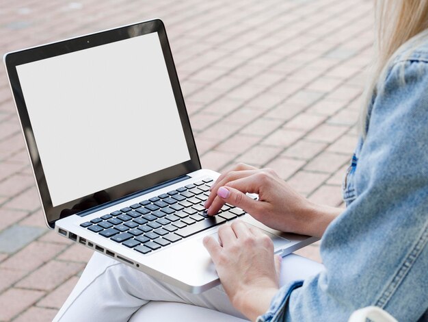 Mujer que trabaja en la computadora portátil afuera