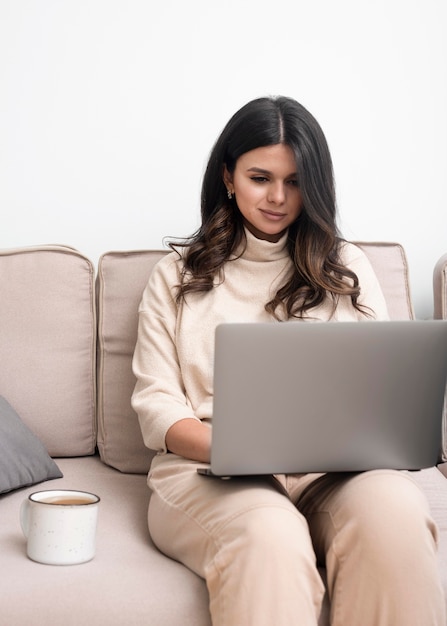 Mujer que trabaja en la computadora portátil y con café