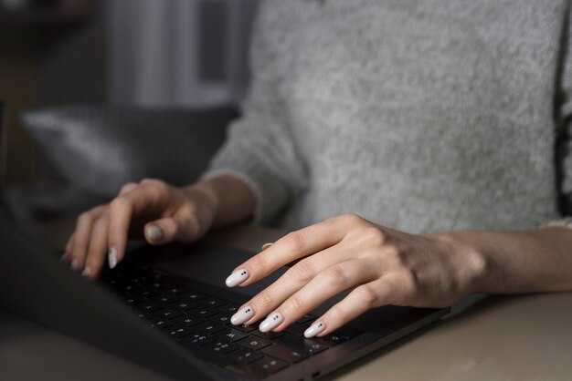 Mujer que trabaja en la computadora portátil durante la noche