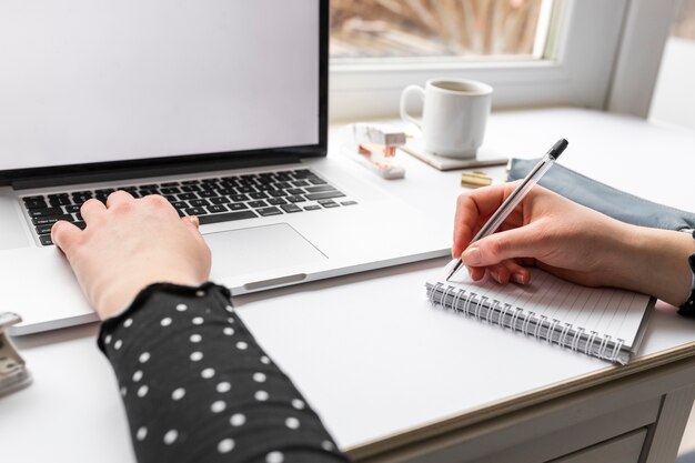 Mujer que trabaja en la computadora portátil y notas de tareas