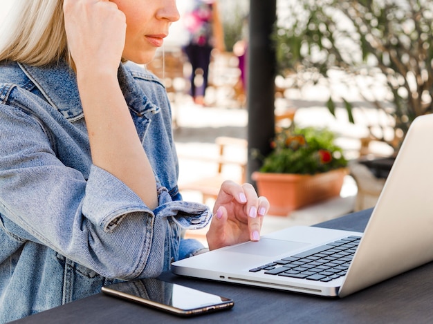 Foto gratuita mujer que trabaja en la computadora portátil con teléfono inteligente