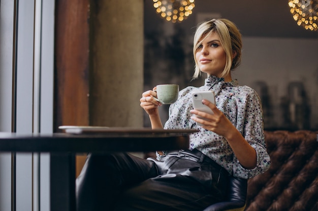 Mujer que trabaja en la computadora y tomando café