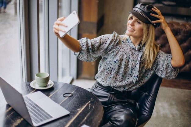 Mujer que trabaja en la computadora y tomando café